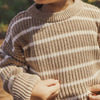 Close-up of a person wearing a brown and beige striped sweater.