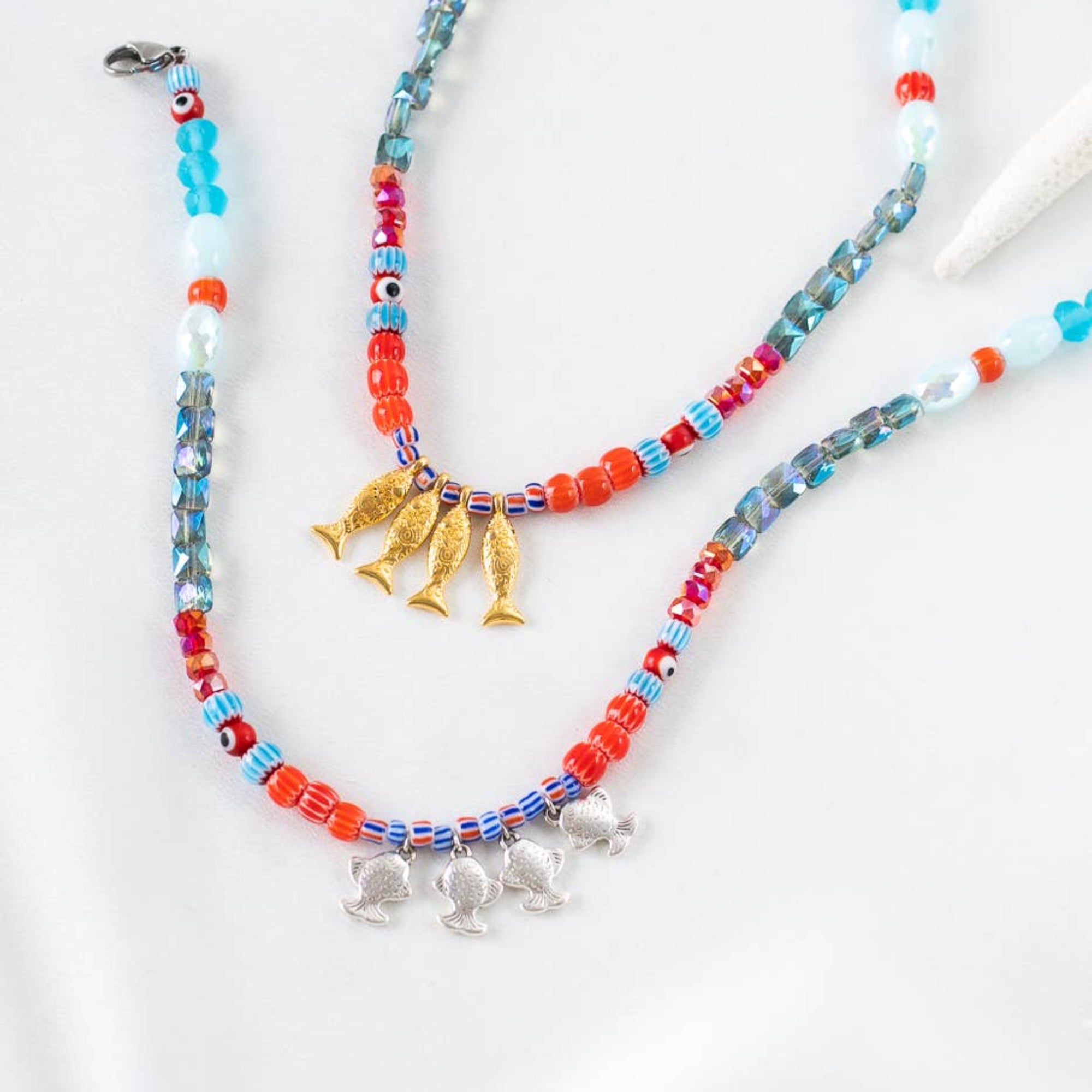 Colorful beaded necklace with charms on a white background