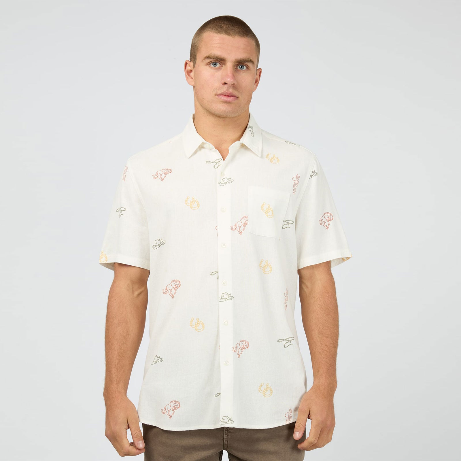 Man wearing a white patterned shirt against a plain background