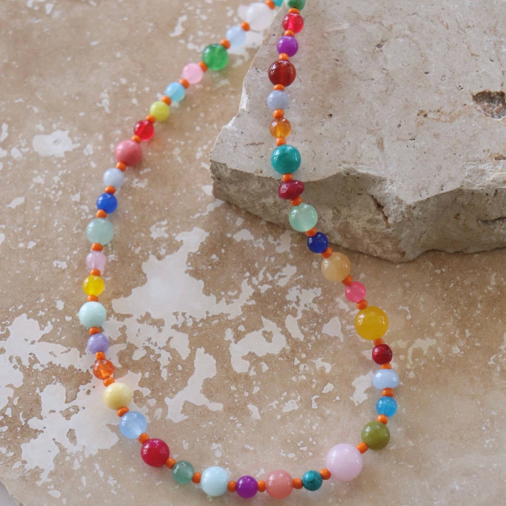 Colorful beaded necklace on a textured stone surface