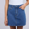 Blue denim skirt worn by a person on a plain background