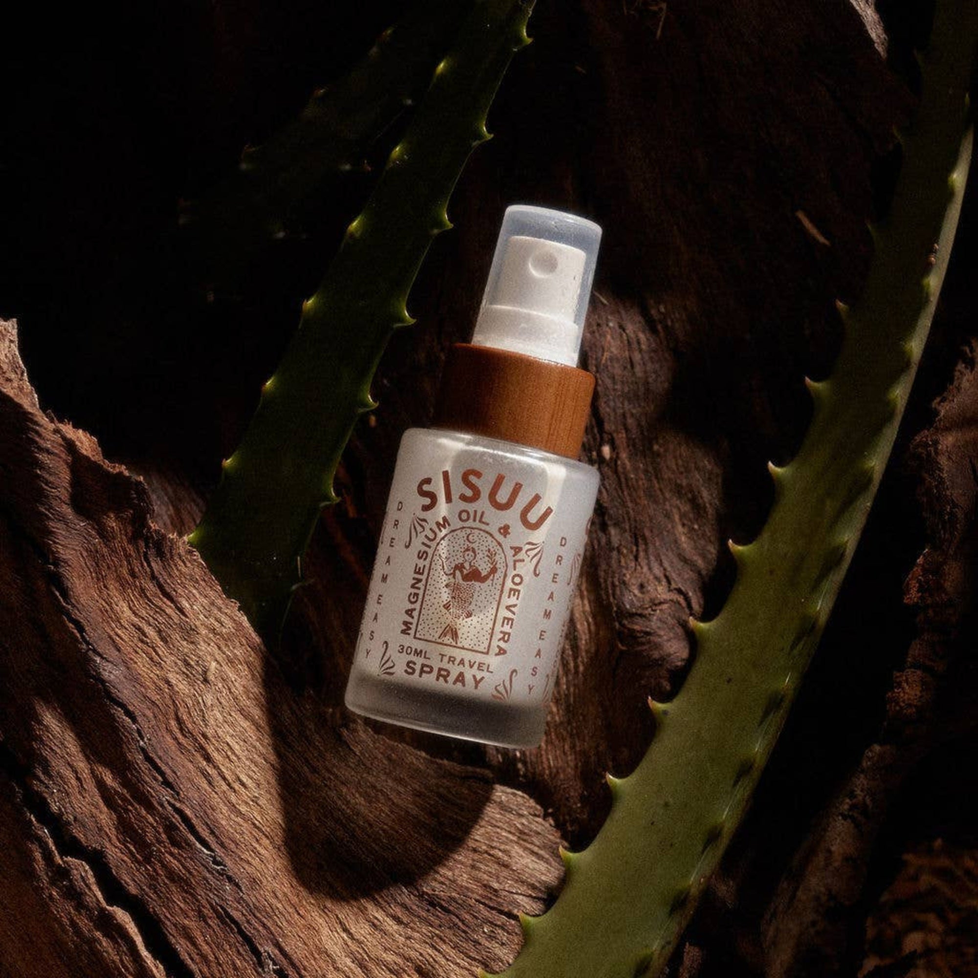 SISUU travel spray bottle on a wooden surface with cactus leaves in the background