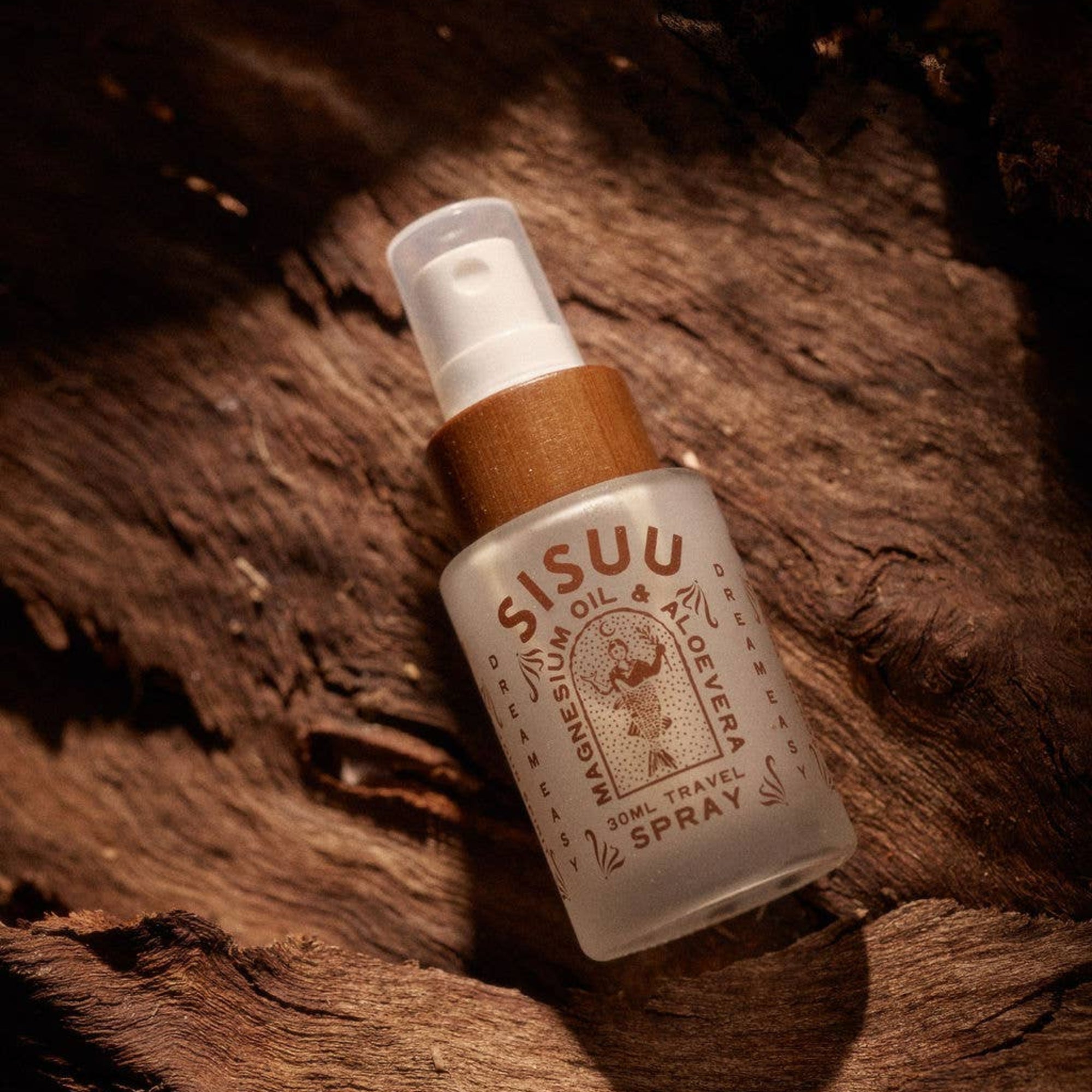 Sisuu magnesium oil spray bottle on a wooden surface
