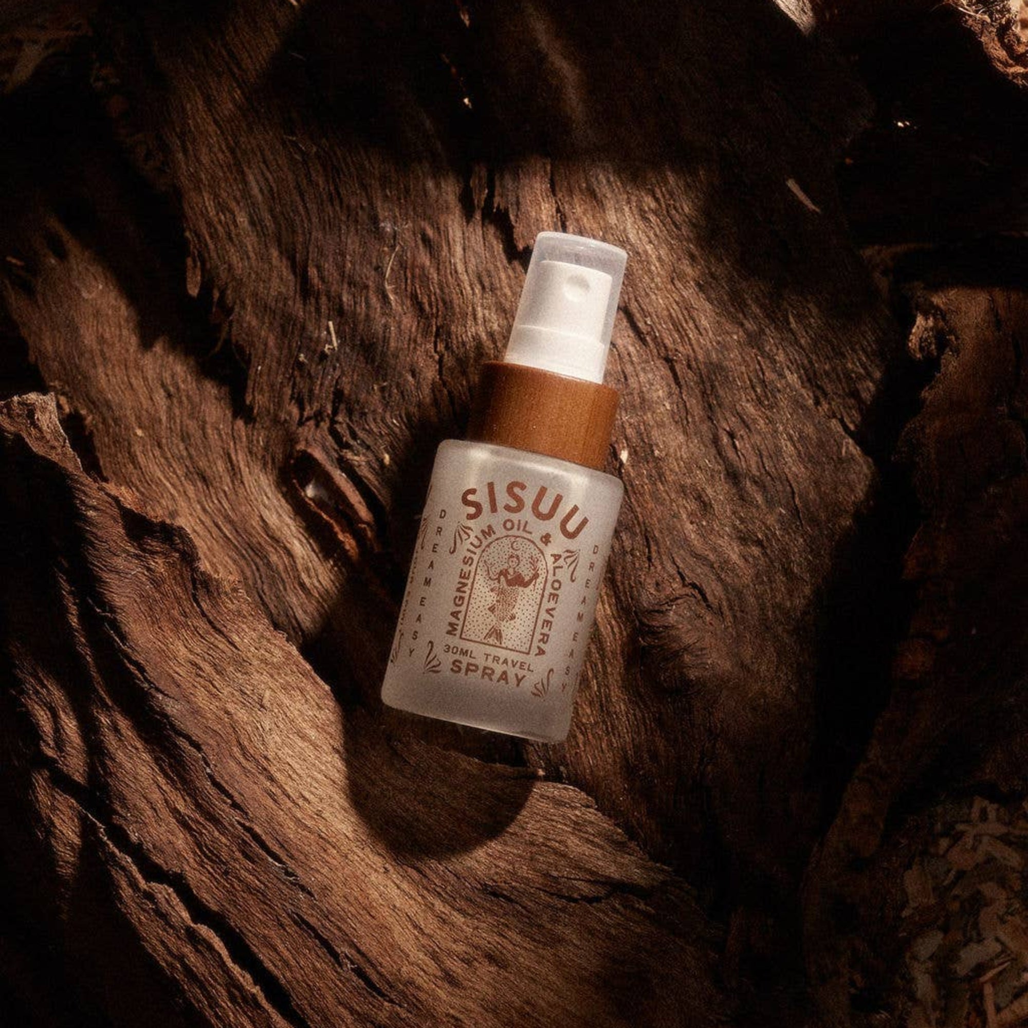 Sisu hair oil spray bottle on a wooden surface