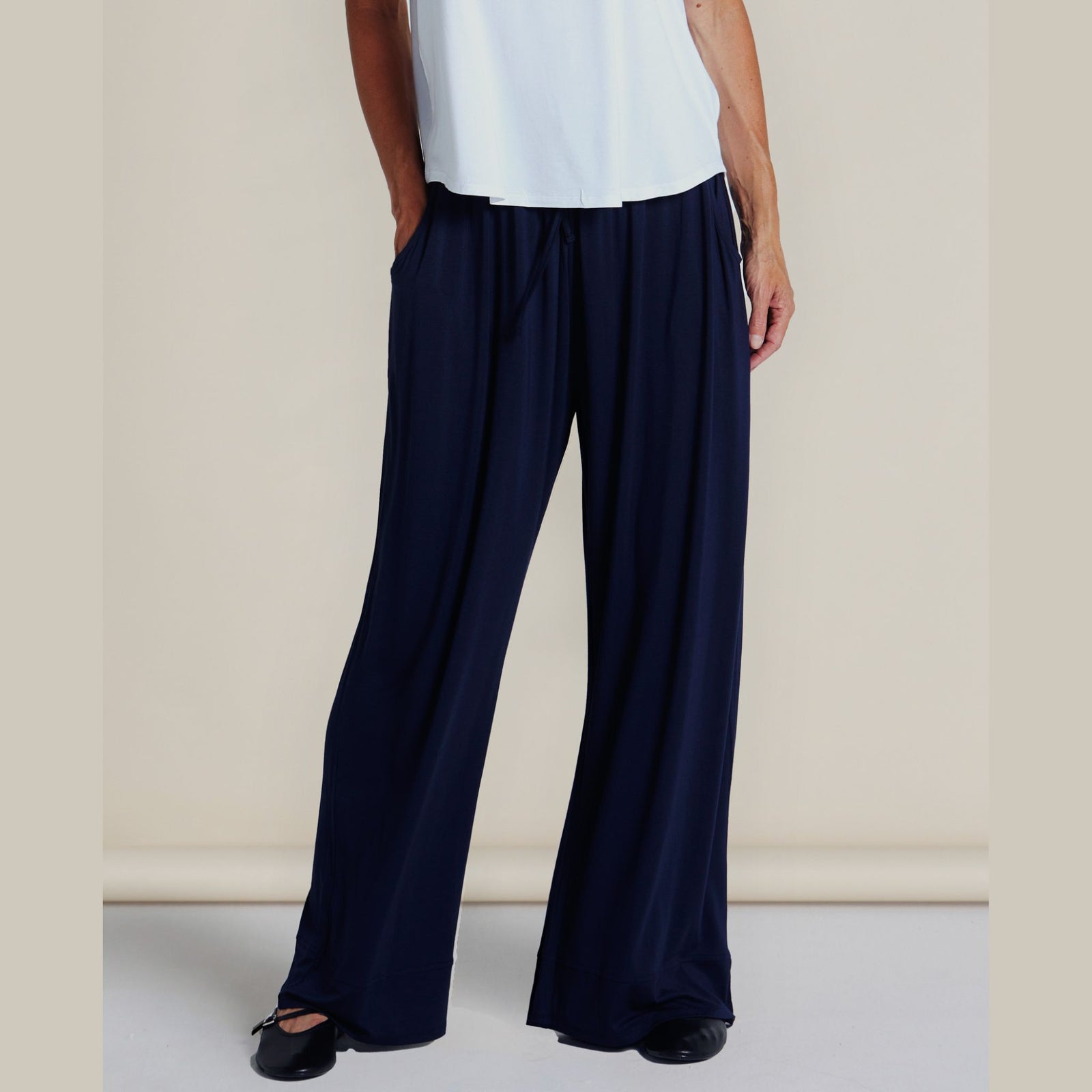 Person wearing black wide-leg pants on a plain background