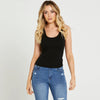 Woman wearing blue jeans and a black top on a white background