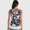 Woman wearing a sleeveless top and pants with a black floral pattern on a white background