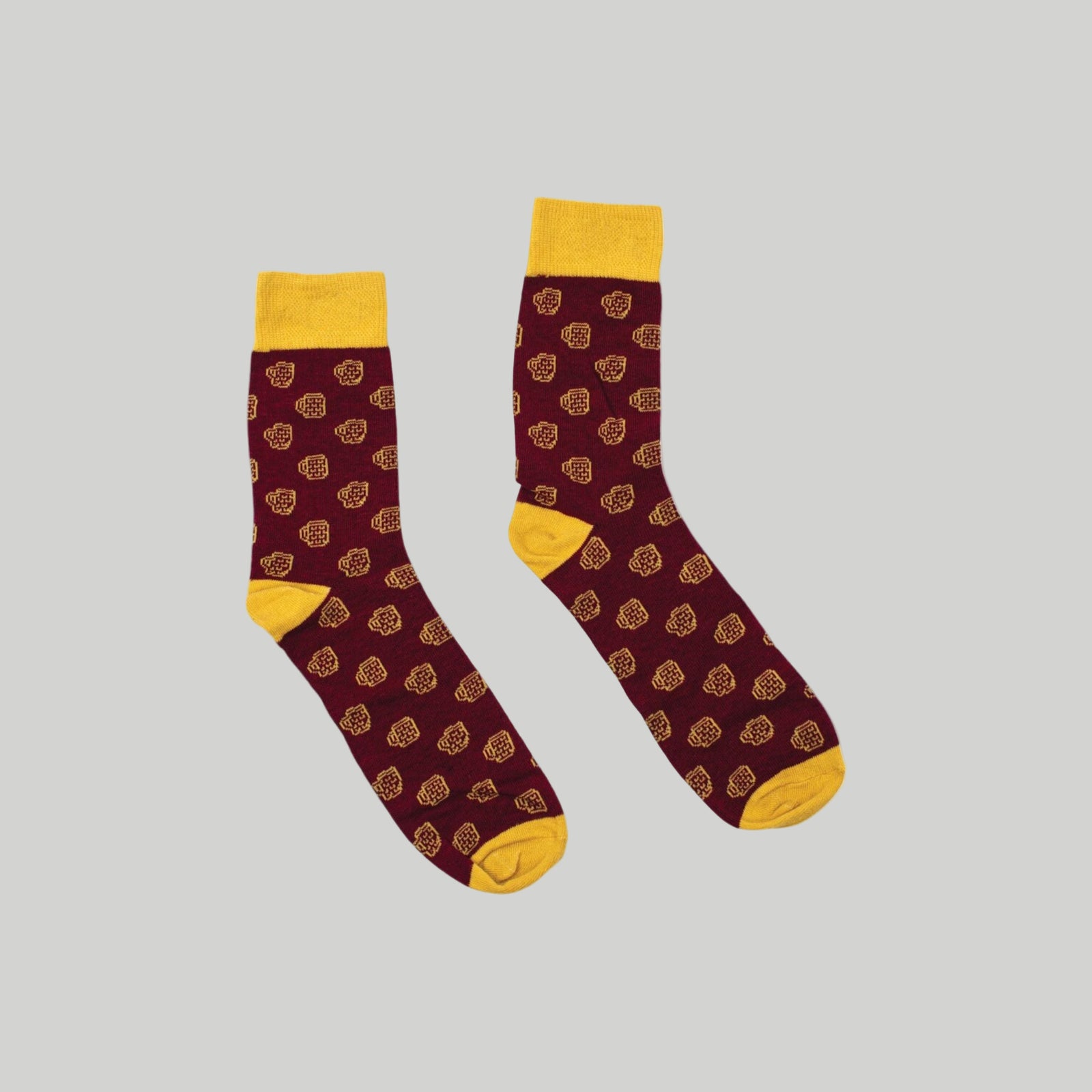 Maroon socks with yellow accents and pattern on a white background