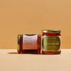 Two jars of honey from &#39;Hive &amp; Harvest&#39; on a beige background