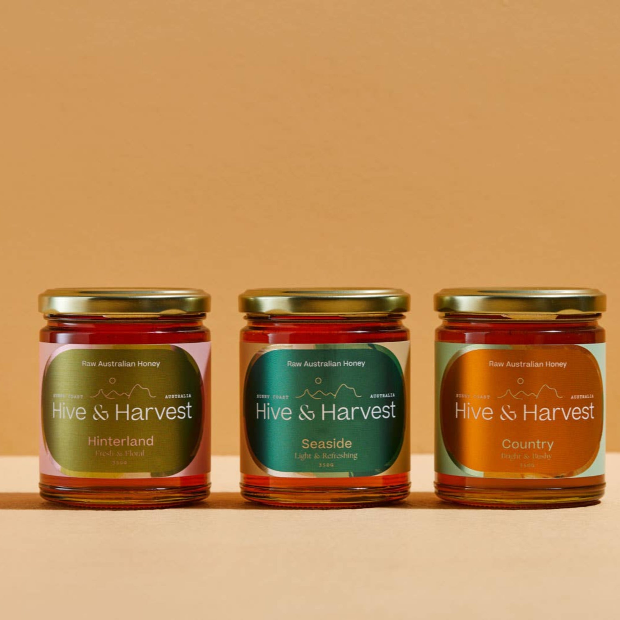 Three jars of &#39;Hive &amp; Harvest&#39; on a beige background