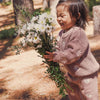 Child holding a bouquet of flowers outdoors