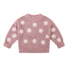 Pink sweater with white snowflake patterns on a white background