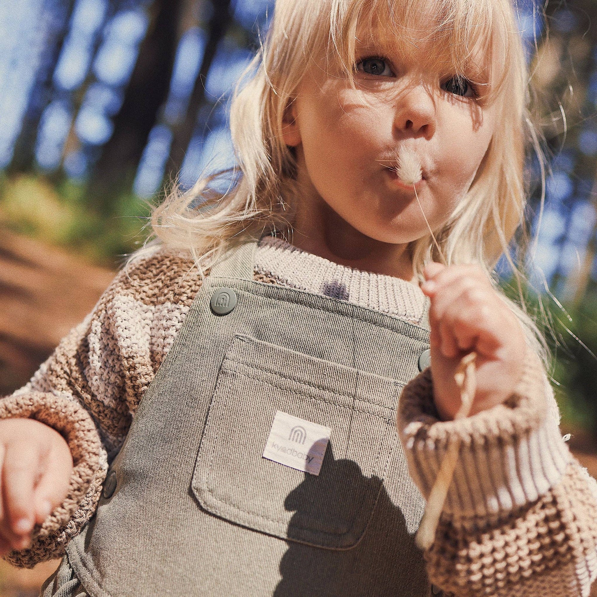 Child blowing bubbles outdoors with a blurred natural background
