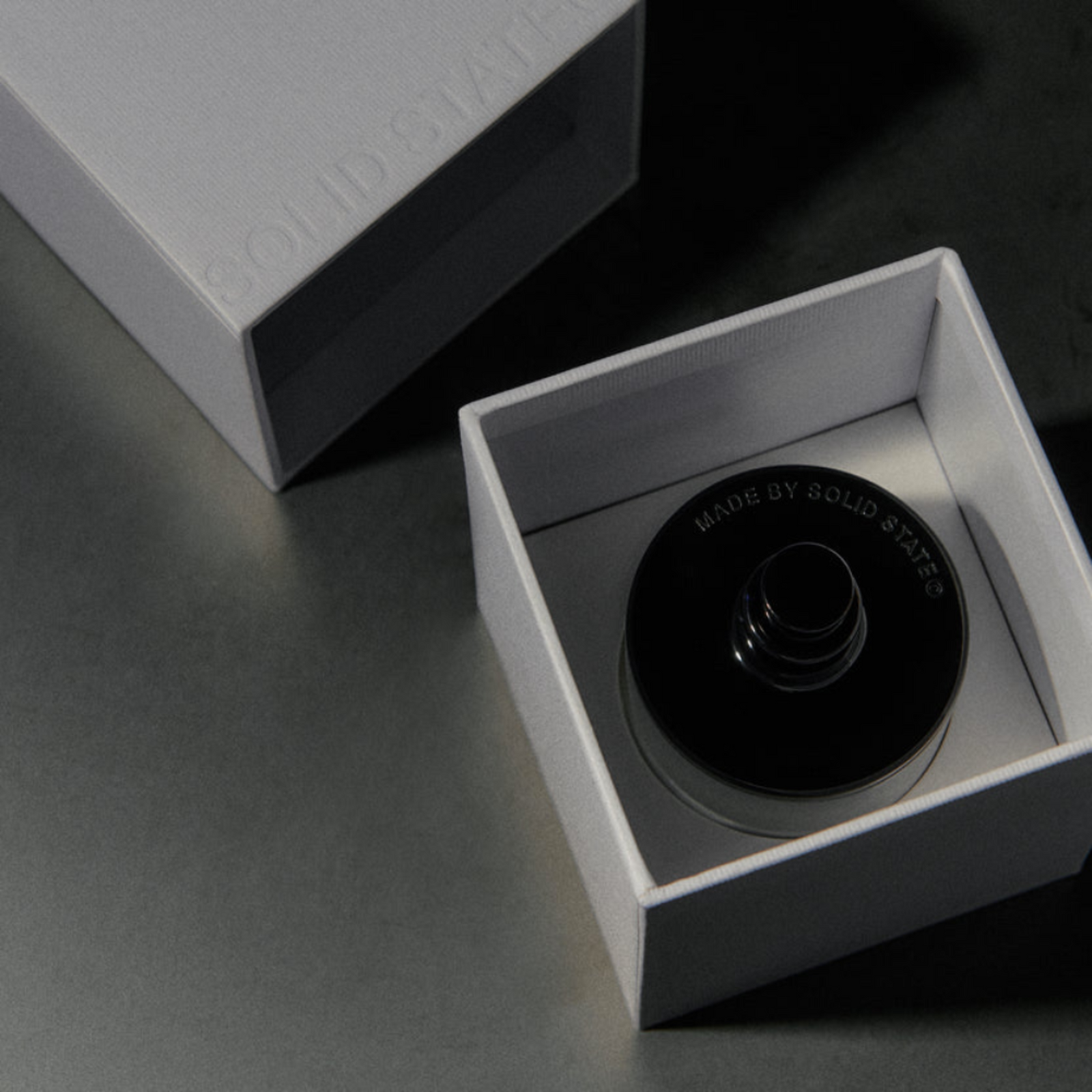 A bottle of Aviator EDP perfume with a black cap on a dark background, emphasizing the sleek design.