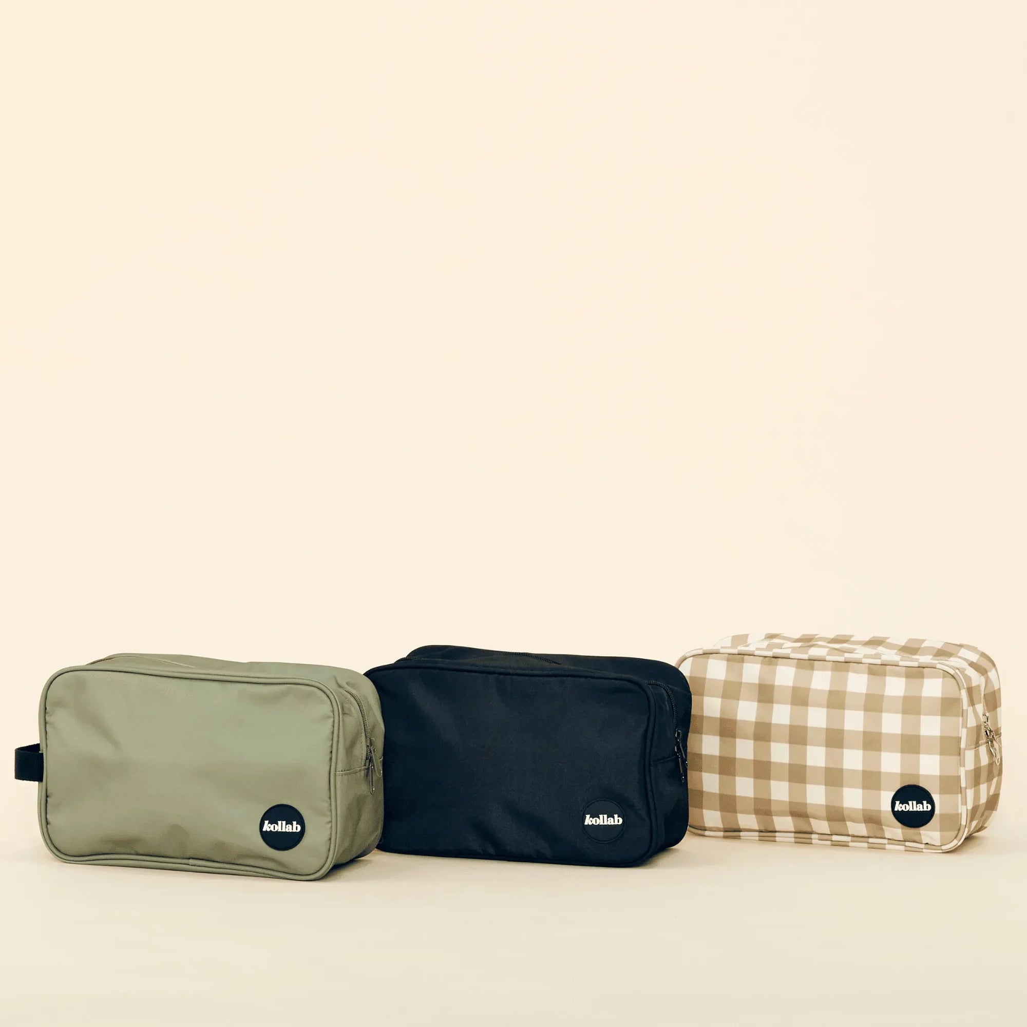 Three toiletry bags in different colors on a beige background