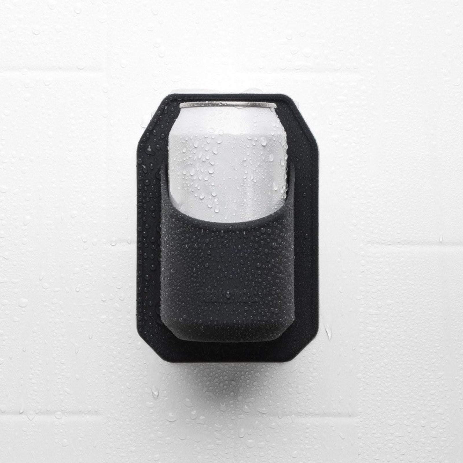 Hand placing a can into a black wall-mounted drink holder.